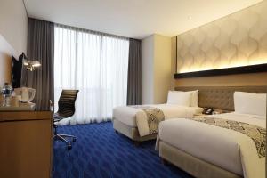 Postel nebo postele na pokoji v ubytování AI Hotel Jakarta Thamrin