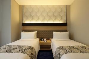 Postel nebo postele na pokoji v ubytování AI Hotel Jakarta Thamrin