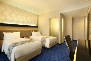 Postel nebo postele na pokoji v ubytování AI Hotel Jakarta Thamrin