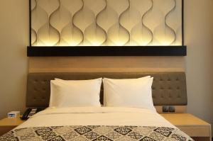 Postel nebo postele na pokoji v ubytování AI Hotel Jakarta Thamrin