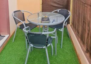 een tafel en twee stoelen op het gras bij Apartamento con Aire Acondicionado, Wifi y Parking - by Aloha Palma in Águilas