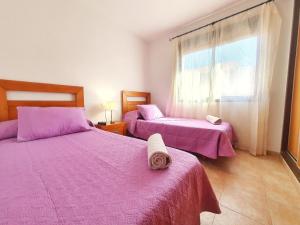 twee bedden in een kamer met roze lakens en een raam bij Apartamento con Aire Acondicionado, Wifi y Parking - by Aloha Palma in Águilas
