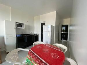 a kitchen with a table and chairs and a refrigerator at Condominio Boa Vista in Pontal do Paraná