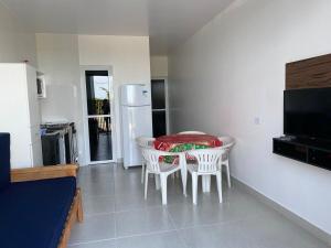 uma cozinha com uma mesa e cadeiras e um frigorífico em Condominio Boa Vista em Pontal do Paraná