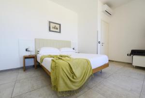 a bedroom with a bed with a yellow blanket on it at Best Western Hotel Martello in Lampedusa