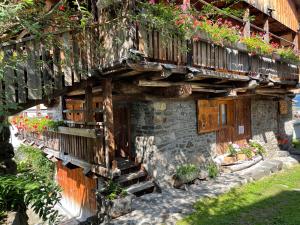 un edificio de piedra con un balcón con flores. en Chalet Sottoguda en Rocca Pietore