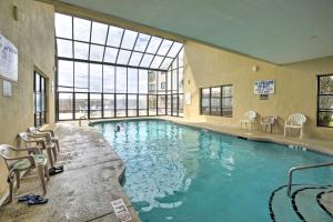 a large swimming pool with chairs and a large window at Ocean-View Penthouse Condo in North Myrtle Beach! in Myrtle Beach