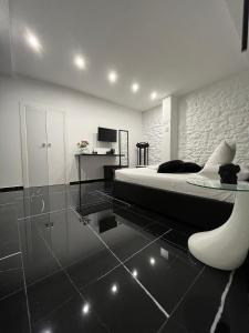 czarno-biała sypialnia z łóżkiem i krzesłem w obiekcie Supriani Luxury B&B w mieście Acquaviva delle Fonti