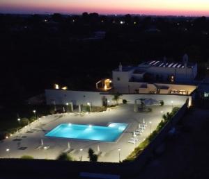 a view of a swimming pool at night at Masseria Del Crocifisso in Polignano a Mare