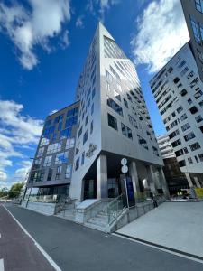un grand bâtiment dans une rue avec deux grands bâtiments dans l'établissement ARENA Junior Suite, à Tampere