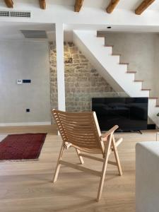 une chaise dans un salon avec un escalier dans l'établissement Ancient & Modern, à Šibenik