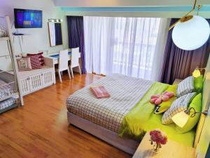 a bedroom with a bed with a green comforter at Exclusive Family Suites 5-6 Pax @ Sunway Pyramid in Petaling Jaya