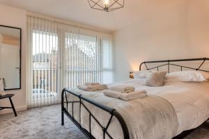 1 dormitorio con 1 cama grande y toallas. en Casa Cella - Centrally located 4 bedroom house with private driveway and garden en Kent