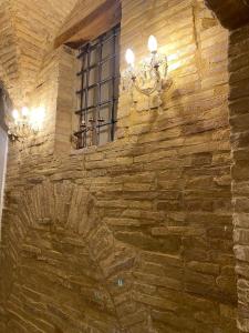 a stone wall with a window and a chandelier at Le tre scimmiette in Lanciano