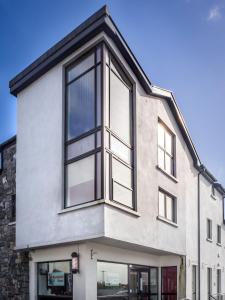 una imagen de una casa con ventanas negras en Carraroe Apartment 2, en Carraroe