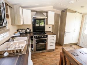 a kitchen with a sink and a stove at 19 The Brambles in Humberston