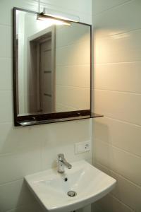 a bathroom with a sink and a mirror at Solo Apartment Dragomanova in Kyiv