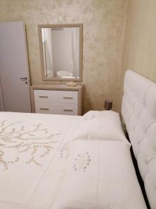 a bedroom with a white bed and a mirror at IN CENTRO in Porto SantʼElpidio