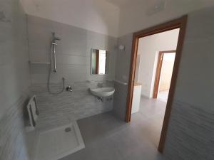 a bathroom with a shower and a sink and a tub at La Marina Bay in Vieste