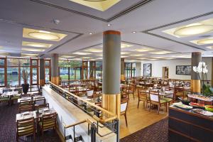 a restaurant with tables and chairs in a room at Fanhams Hall, Exclusive Collection in Ware +61 photos