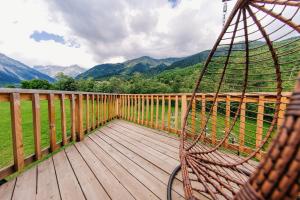 a hammock on a deck with a view of mountains at WinterFell Mestia in Mestia
