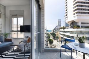an apartment with a balcony with a view of the city at Bauhaus Boutique by TLV2rent in Tel Aviv
