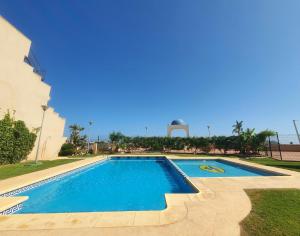 une piscine en face d'un bâtiment dans l'établissement Preciosas Vistas con Aire Acondicionado y aparcamiento - by Aloha Palma, à Águilas