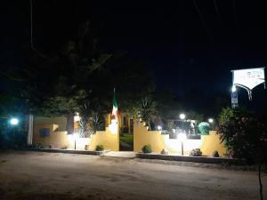 a yellow building with a flag on it at night at MEMO'S Affittacamere in Arborea +36 photos