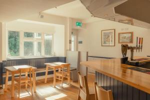 a kitchen with a counter and tables and chairs at Ballinluig Rooms & Suites in Pitlochry