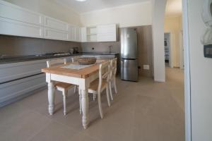 a kitchen with a table and chairs and a refrigerator at CasaRizzo in Torre dell'Orso