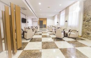 een conferentieruimte met stoelen en een dambordvloer bij Balneario de Archena - Hotel Levante in Archena