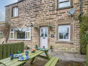 a picnic table in front of a brick house at Peak Cottage in Bakewell
