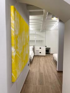 uma sala de estar com uma pintura amarela na parede em Raha Suites em Siracusa
