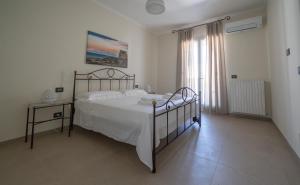 a white bedroom with a bed and a window at CasaRizzo in Torre dell'Orso