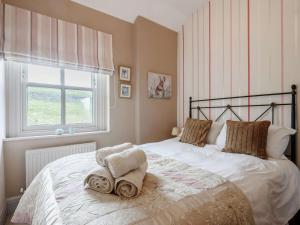 a bedroom with a bed with towels on it at Peak Cottage in Bakewell