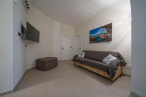 a living room with a couch and a flat screen tv at CasaRizzo in Torre dell'Orso