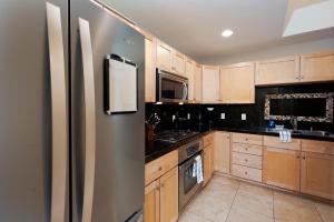 a kitchen with wooden cabinets and a stainless steel refrigerator at Mears House Unit 3C in Durango