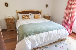 um quarto com uma cama e duas mesas de cabeceira em Casa das Regueiras em Santiago de Compostela