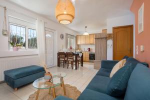un salon avec un canapé bleu et une cuisine dans l'établissement Casa Callianeira Residence, à Tsilivi