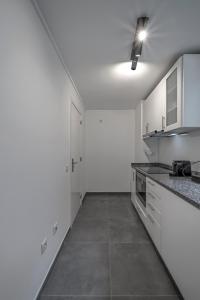 een keuken met witte kasten en granieten aanrechtbladen bij Oporto Near Poveiros in Porto