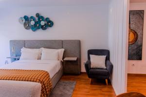 een slaapkamer met een bed en een stoel bij Oporto Near Poveiros in Porto