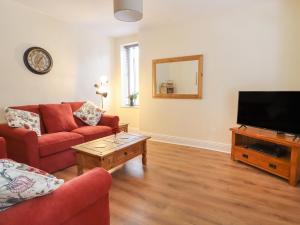 a living room with two couches and a flat screen tv at 45 Prince Street in Keighley