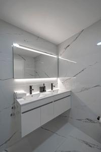 een witte badkamer met een wastafel en een spiegel bij Oporto Near Poveiros in Porto