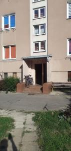 APARTAMENT DWUPOKOJOWY في أوستروفيتس شفينتوكجسكي: مبنى به دراجة متوقفة أمامه