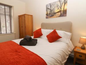 a bedroom with a bed with red and white pillows at 45 Prince Street in Keighley