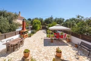 un patio avec une table, des chaises et un parasol dans l'établissement Casa Callianeira Residence, à Tsilivi