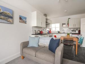een woonkamer met een bank en een keuken bij Rooby's Retreat in Lyme Regis