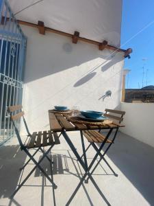 une table et deux chaises assises sur un balcon dans l'établissement Dimora PietrAnima, à Bari