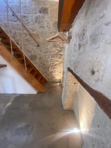 - un escalier dans une chambre dotée d'un mur en pierre dans l'établissement Dimora PietrAnima, à Bari