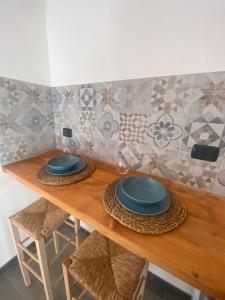 une table en bois avec des plaques bleues au-dessus dans l'établissement Dimora PietrAnima, à Bari